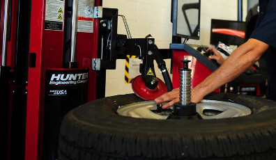 Wheel Service Equipment Mechanic performing tire and wheel service with a tire changer